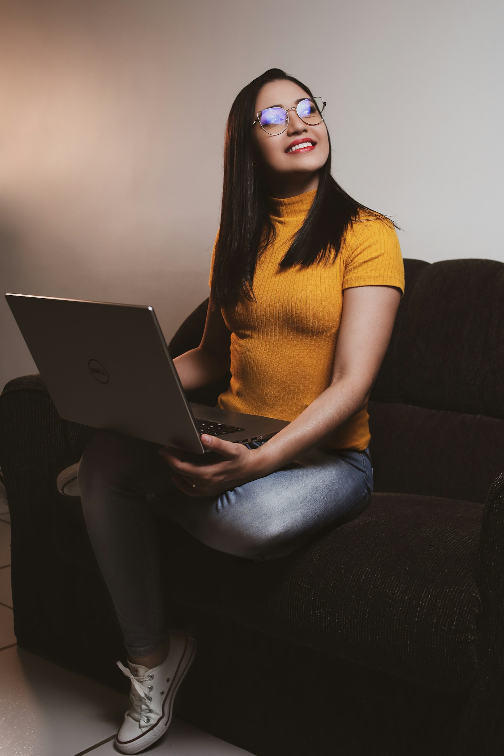 Woman sitting on a couch with a laptop